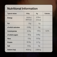 A Nutrition Information label showing typical values per 100g and 6g serving for energy, fat, carbohydrates, fibre, protein, salt, and sodium, with a light gray rounded-corner background.